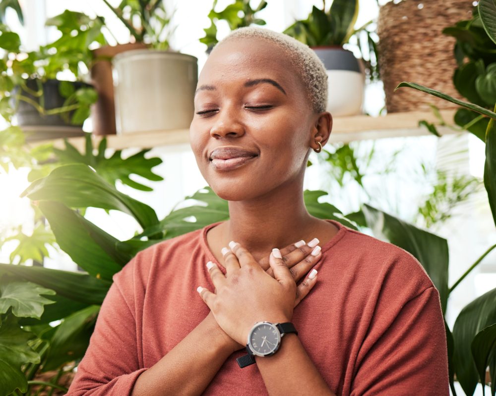 Balance, breathing and young woman by plants for zen meditation in a greenery nursery. Breathe, gratitude and young African female person with a relaxing peace mindset by an indoor greenhouse garden. Balance, breathing and young woman by plants for zen meditation in a greenery nursery. Breathe, gratitude and young African female person with a relaxing peace mindset by an indoor greenhouse garden.